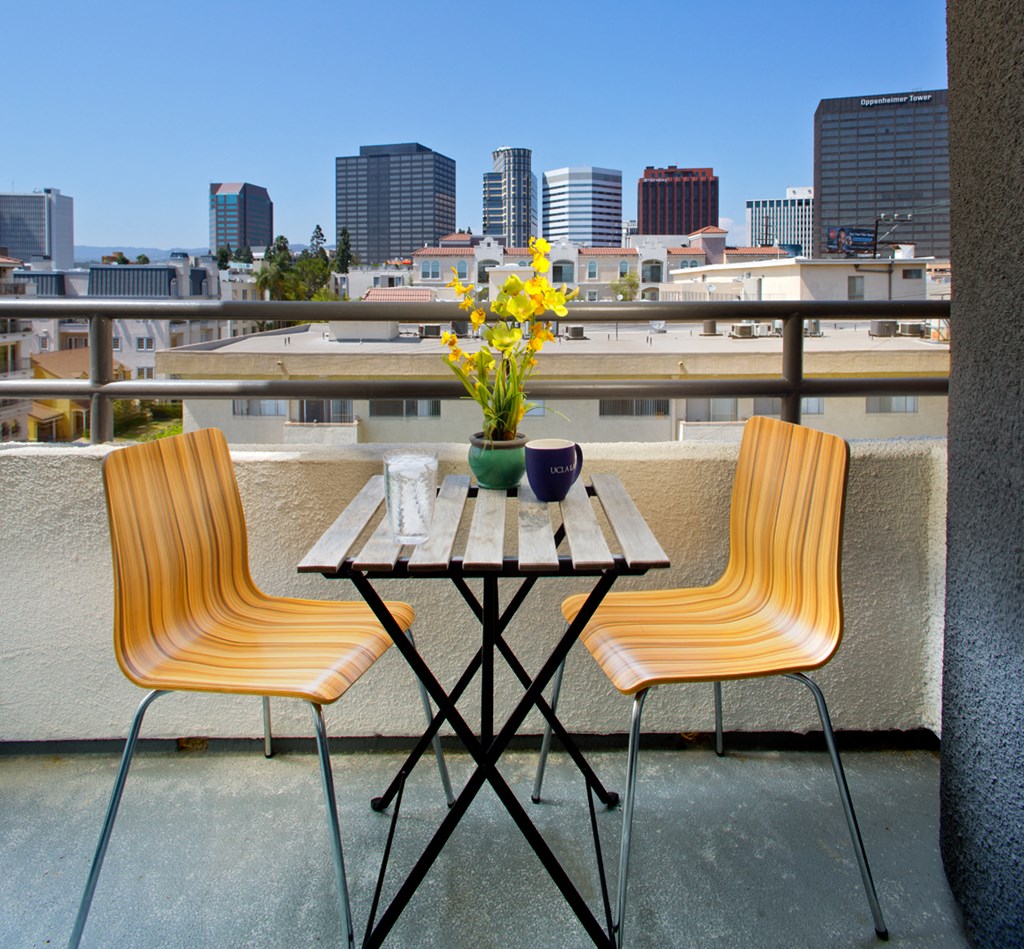 Apartment balcony with a cafe table and chairs with city views. at Midvale Court, California