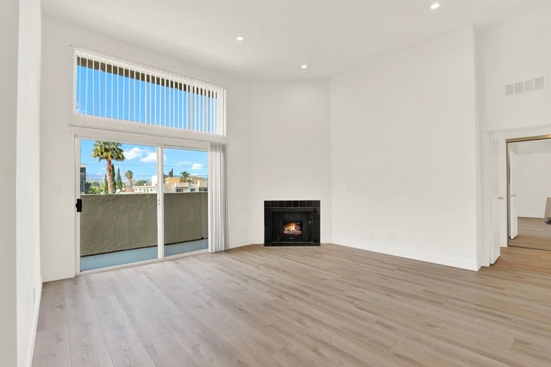 A living room with a fireplace and sliding glass doors.