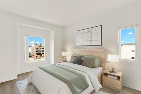 A bedroom with a large bed and a window overlooking a cityscape.