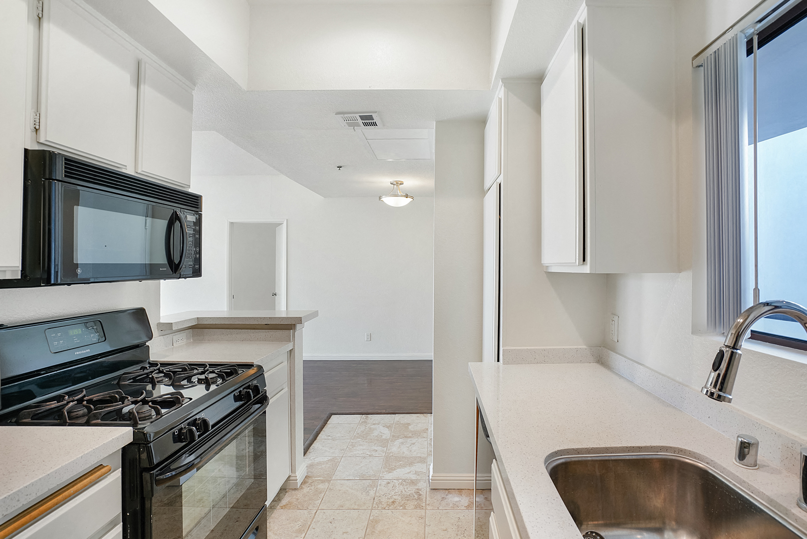 a kitchen with a sink and a stove and a microwave