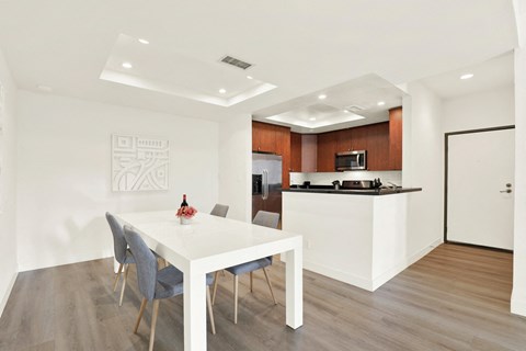 A modern dining room with a white table and grey chairs at Twelve One Ten Rochester, California
