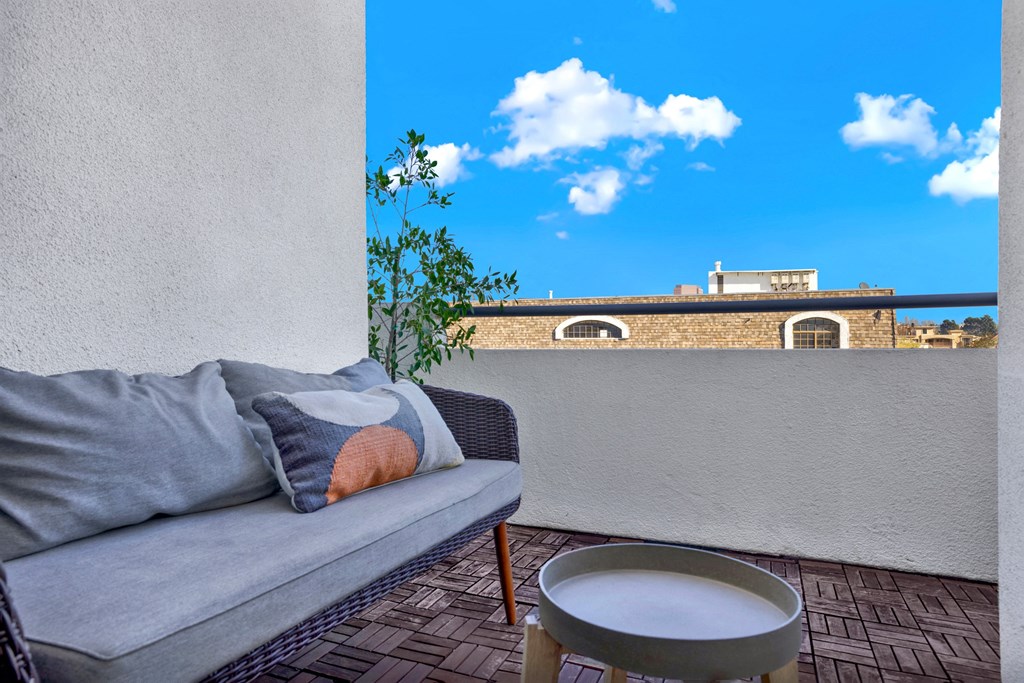 A grey couch with a pillow and a bowl on a table at Beverly Wooster Apartments, Los Angeles, California