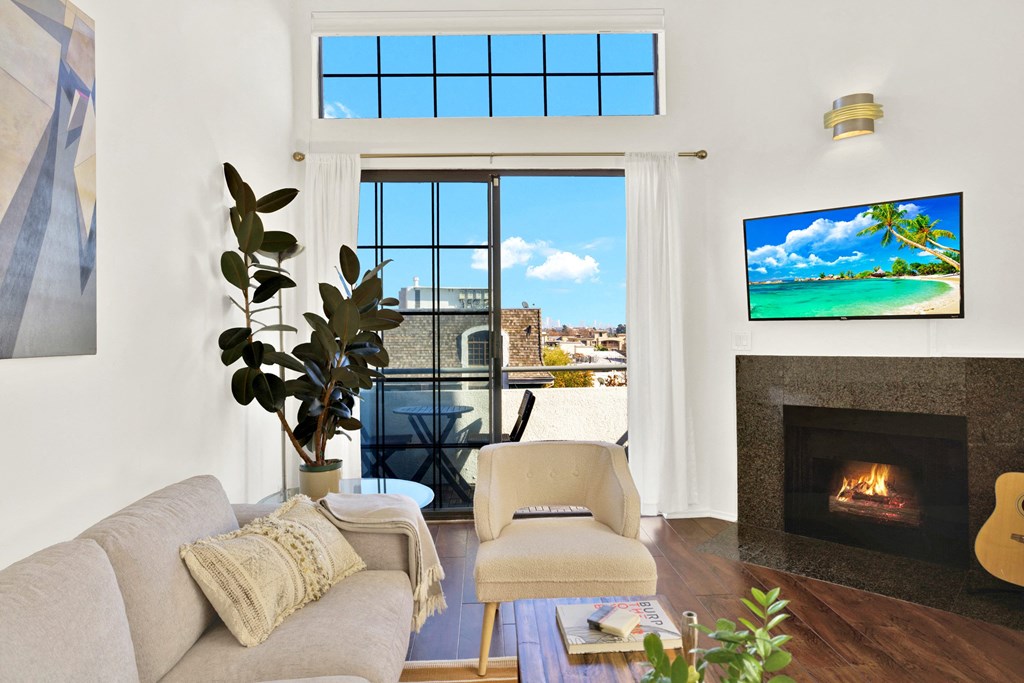 A living room with a fireplace and a flat screen TV at Beverly Wooster Apartments, California
