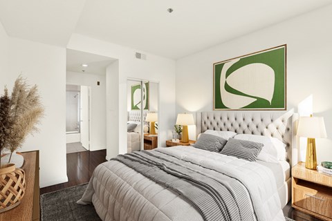 A bedroom with a large bed and a green abstract painting above it.