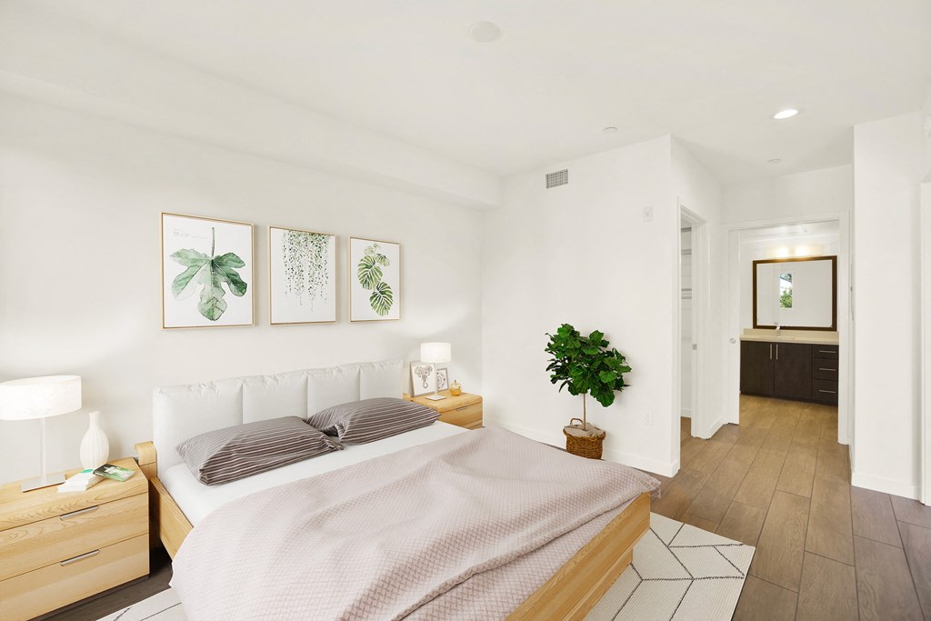 A bedroom with a bed, nightstand, and a plant at The Urbanpolitan, California