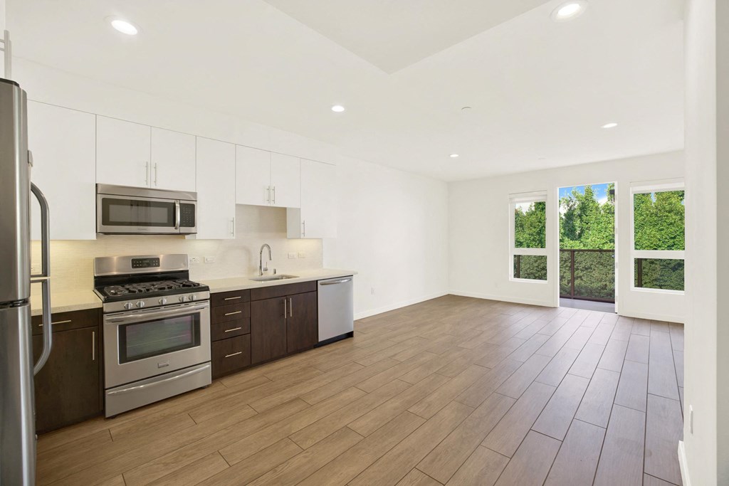 A kitchen with wooden floors and stainless steel appliances at The Urbanpolitan, Los Angeles