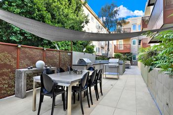 A patio with a table and chairs under a shade sail at The Urbanpolitan, California