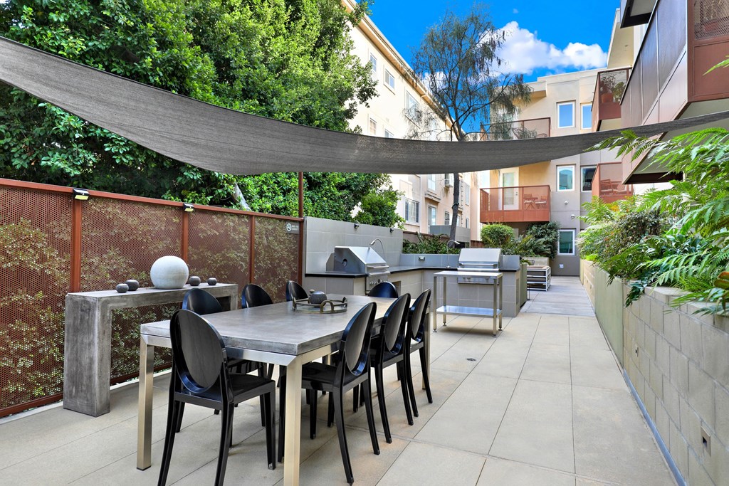A patio with a table and chairs under a shade sail at The Urbanpolitan, Los Angeles, 90036