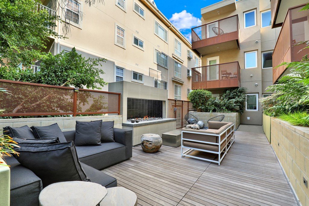 A patio with a black couch and a wooden table at The Urbanpolitan, California