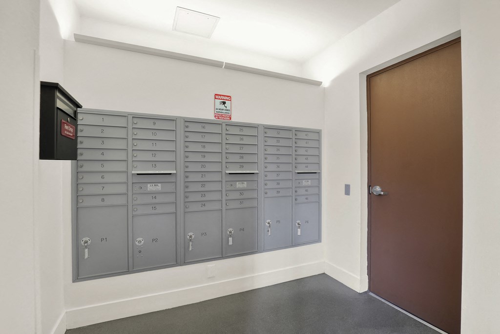 A row of mailboxes are lined up against a wall at The Urbanpolitan, Los Angeles, California