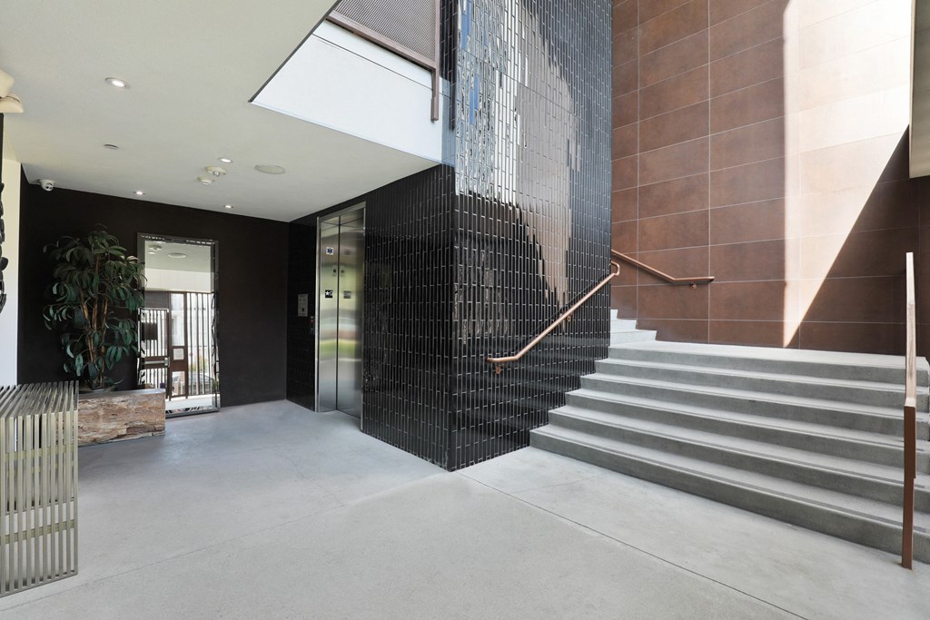 A staircase with a metal railing and a wall with a picture of a man on it at The Urbanpolitan, California