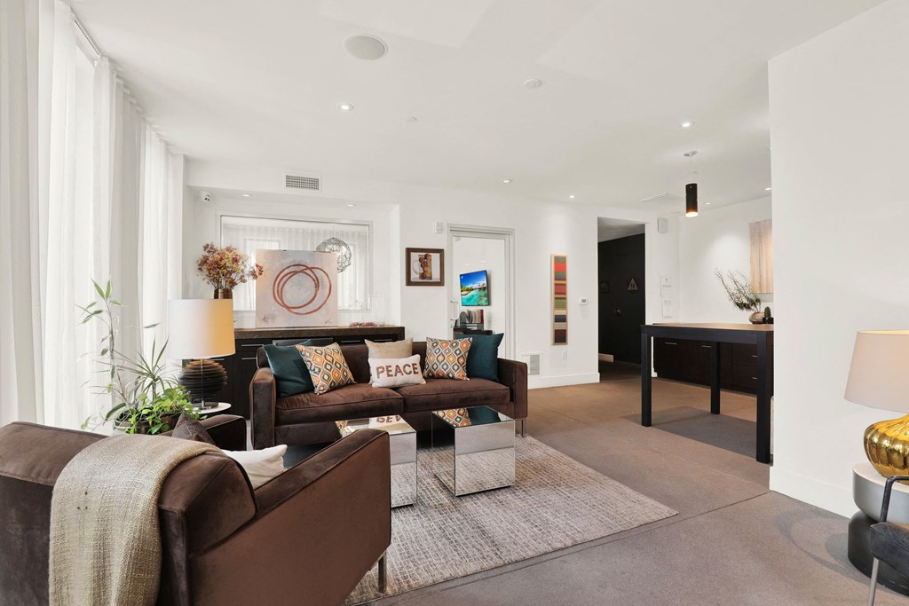 A living room with a brown couch and a white rug at The Urbanpolitan, Los Angeles, 90036