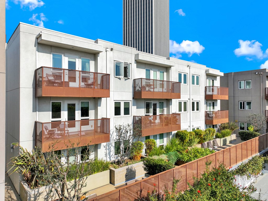 A row of modern apartment buildings with balconies and plants in front at The Urbanpolitan, California 90036