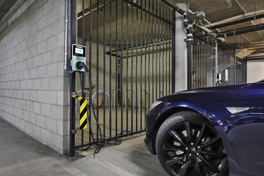 A car is parked in a garage next to a gate with a digital display at The Urbanpolitan, Los Angeles