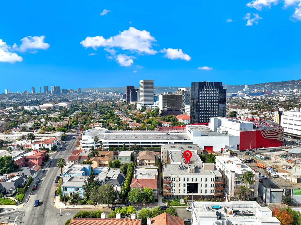 A cityscape with a mix of residential and commercial buildings under a clear blue sky at The Urbanpolitan, Los Angeles