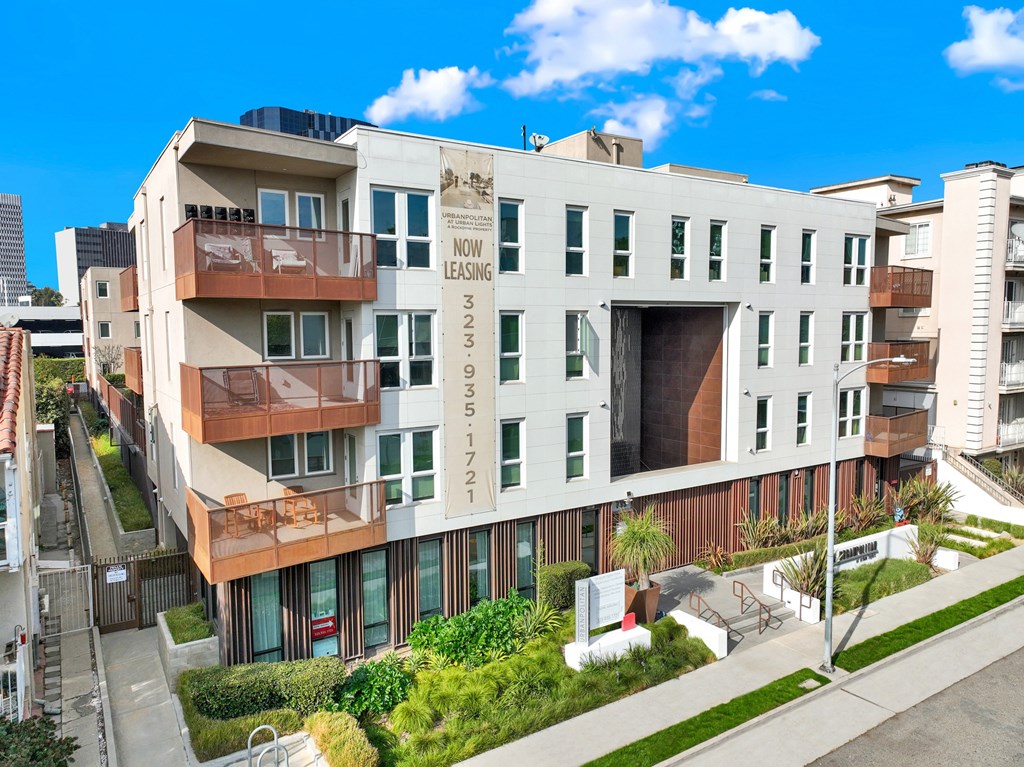 A modern apartment building with a sign at The Urbanpolitan, Los Angeles, CA