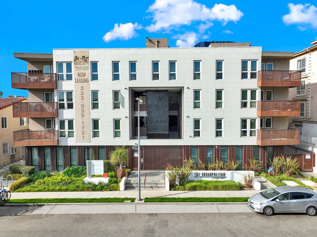 A modern apartment building with a sign that says at The Urbanpolitan, California