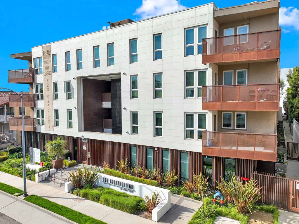 A modern apartment building with a white facade and balconies at The Urbanpolitan, Los Angeles, California