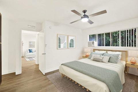 A bedroom with a bed, a ceiling fan, and a window with blinds at Wooster Encore Apartments, Los Angeles, 90035