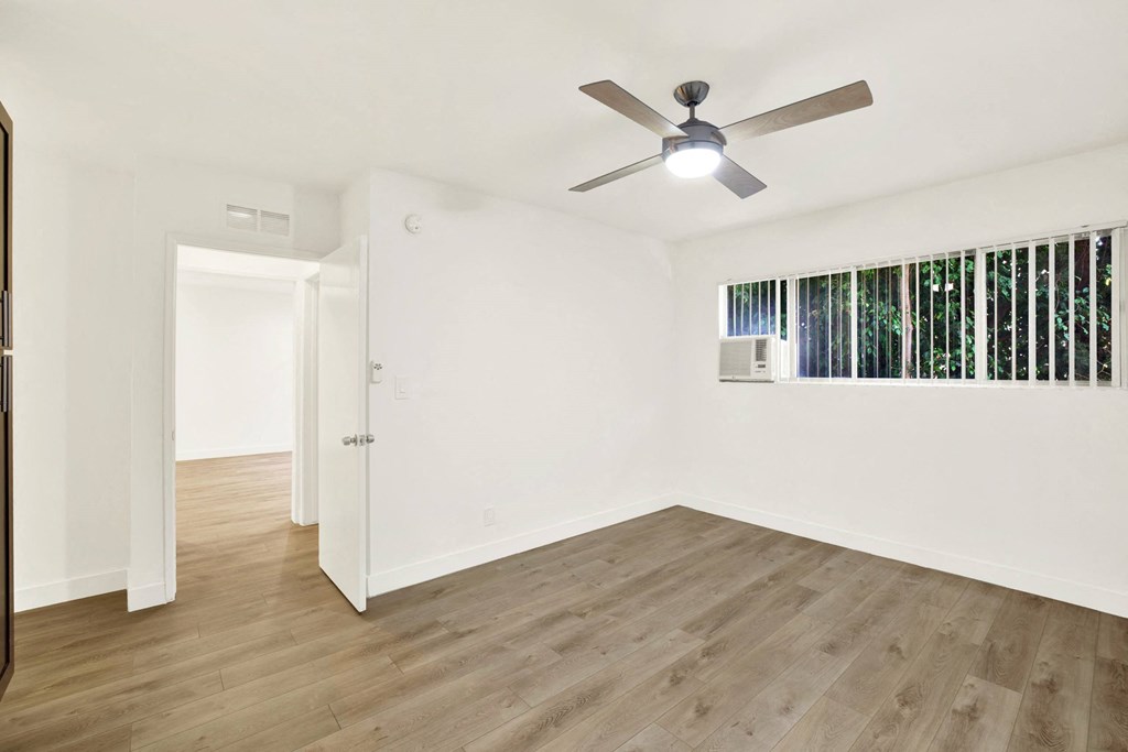 A room with a ceiling fan and wooden flooring at Wooster Encore Apartments, California