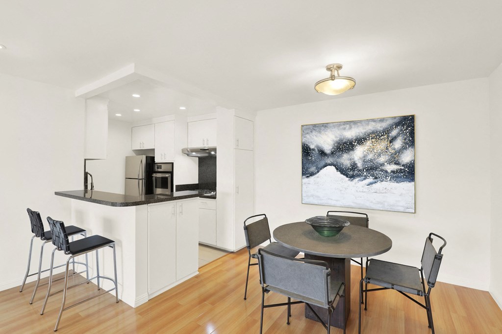 A modern kitchen with a dining table and chairs at Wooster Encore Apartments, Los Angeles, 90035