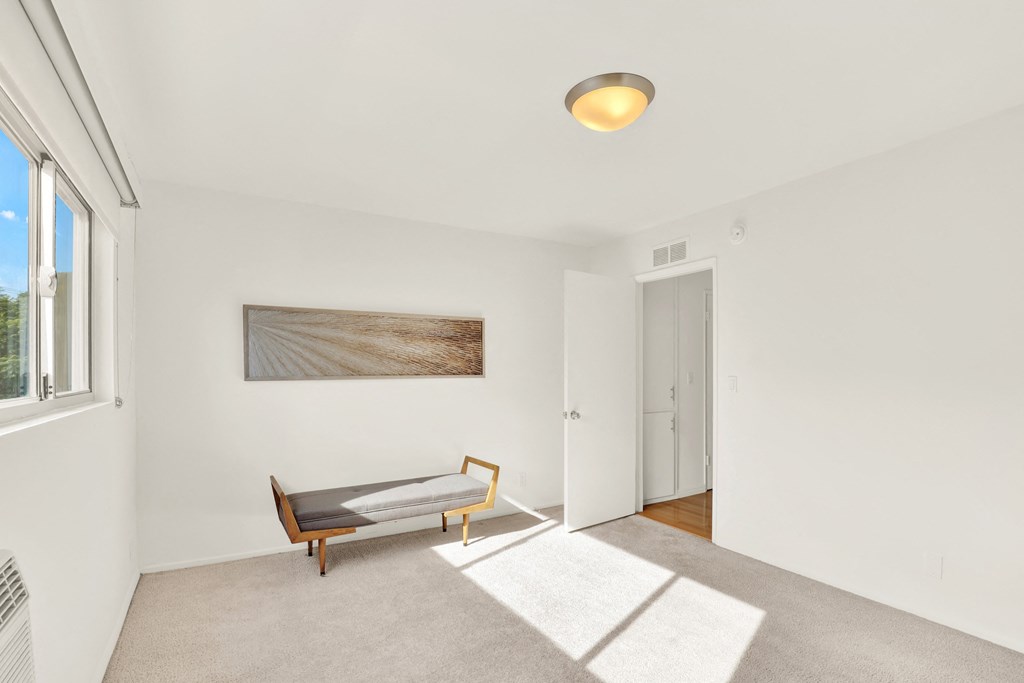 A room with a bench and a painting on the wall at Wooster Encore Apartments, Los Angeles, CA 90035