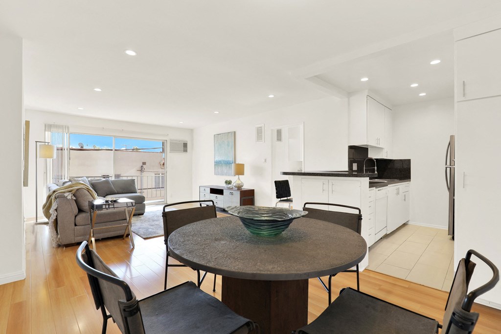 A modern kitchen with a dining table and chairs at Wooster Encore Apartments, Los Angeles, CA