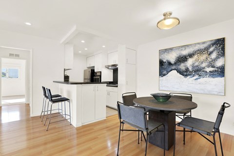 A modern kitchen with a dining table and chairs.