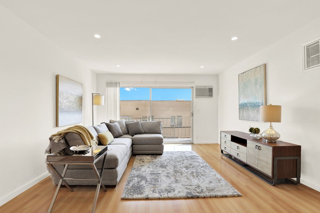 A modern living room with a grey sofa and a wooden floor at Wooster Encore Apartments, California