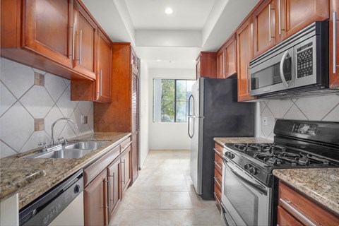 a kitchen with stainless steel appliances and marble counter tops