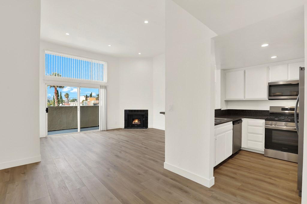 A modern kitchen with a fireplace and a view of the outdoors.
