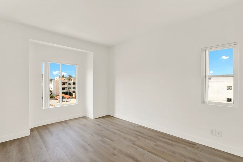 A room with a window showing a view of a building outside.