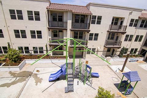 an outdoor playground in front of an apartment building
