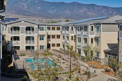 a group of apartments with a pool and mountains in the background