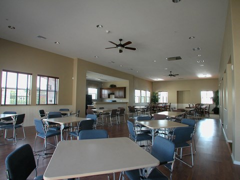 a dining room with tables and chairs and a kitchen