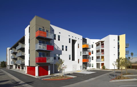 A modern building with white, grey and red balconies.