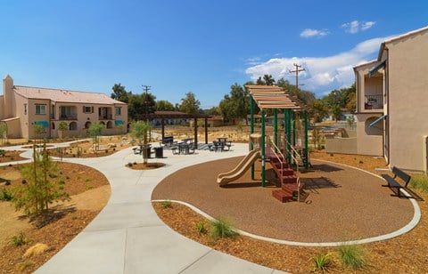 a playground in a community with houses and trees