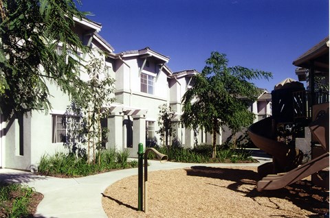 a white house with a playground in front of it
