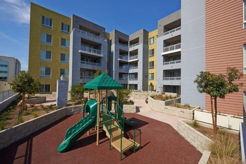 an empty playground in front of an apartment building