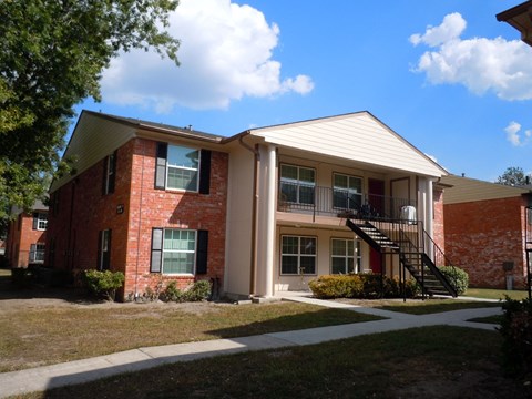 an apartment building with a staircase and a sidewalk