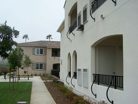 the outside of a building with a sidewalk and grass