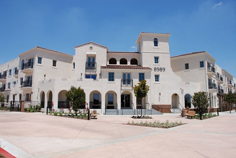 an exterior view of a white building with a courtyard
