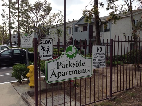 a fence with street signs on it in front of a house