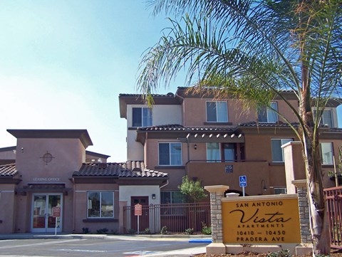 a building with a sign in front of it and a palm tree