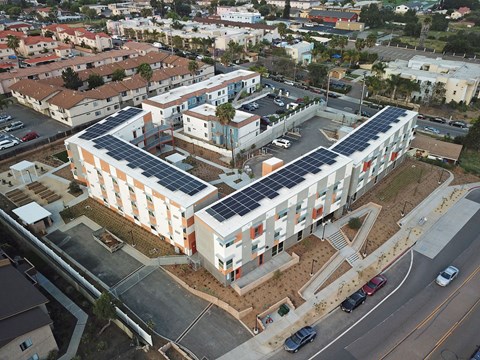 an aerial view of an apartment building with solar panels on the roof