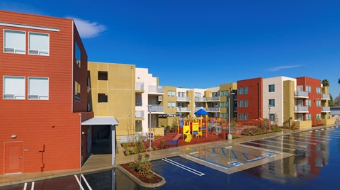 a view of an apartment complex with a playground in the rain