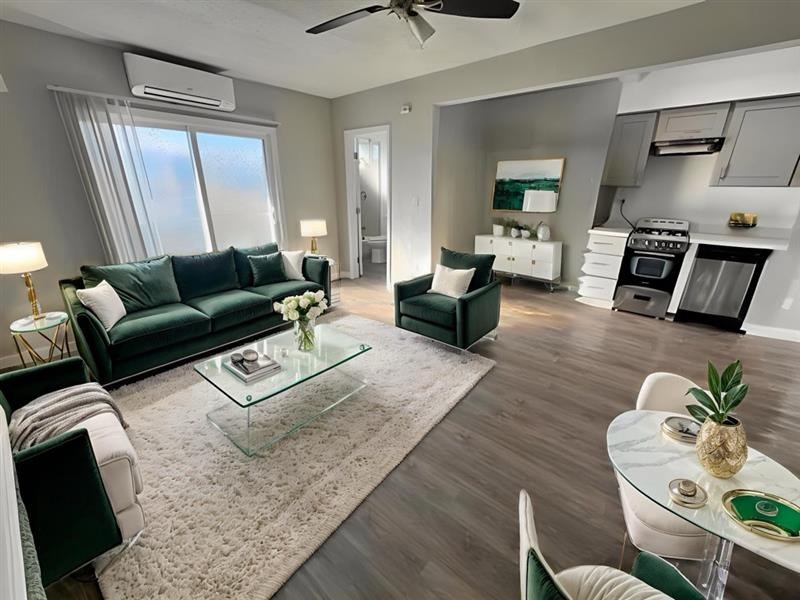 A modern living room with a glass coffee table and a green sofa.