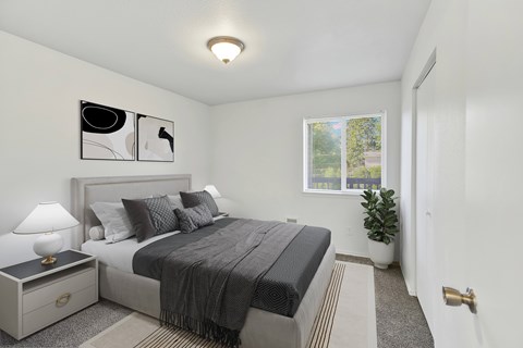 A bedroom with a bed, nightstand, and lamp.