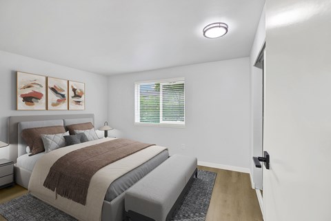 A bedroom with a bed, pillows, a blanket, a nightstand, a lamp, a window with blinds, a rug, a picture on the wall, and a door.
