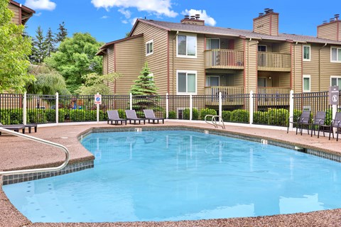 A small pool in front of a building with a fence around it.